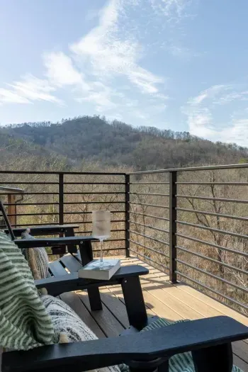 The main level balcony is a peaceful, scenic space accessible from both the living room and master bedroom. It features 4 comfortable chairs, perfect for sipping coffee, enjoying conversations, or simply soaking in the serene, natural surroundings.