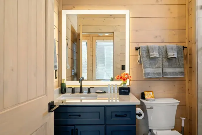 An upstairs bathroom with a queen bedroom, is stocked with everything you need for a comfortable stay. It features a shower, plush towels, and thoughtful amenities like shampoo, conditioner, body wash, lotion, tampons, cotton pads, and Q-tips.
