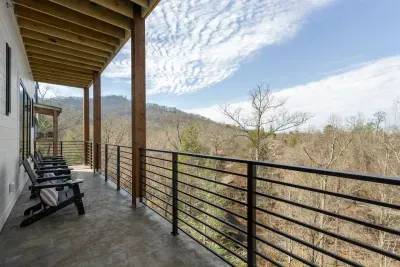 The bottom level balcony is a peaceful, scenic space accessible from both the living room and master bedroom. It features 4 comfortable chairs, perfect for sipping coffee, enjoying conversations, or simply soaking in the serene, natural surroundings.