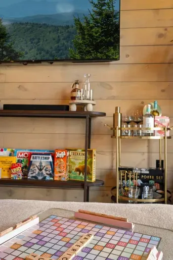 Downstairs, a cozy TV room offers the perfect hangout space—complete with games, soft seating, and a stylish bar cart that’s both aesthetic and functional.