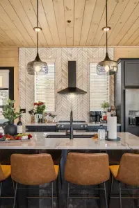 This modern kitchen is bright, open to the main living room, and fully equipped—including kids’ utensils for family-friendly meals. Sleek, functional, and welcoming, it’s designed for both everyday ease and elevated comfort. 4 bar seats pictured.