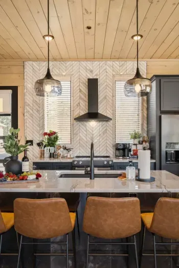 This modern kitchen is bright, open to the main living room, and fully equipped—including kids’ utensils for family-friendly meals. Sleek, functional, and welcoming, it’s designed for both everyday ease and elevated comfort. 4 bar seats pictured.
