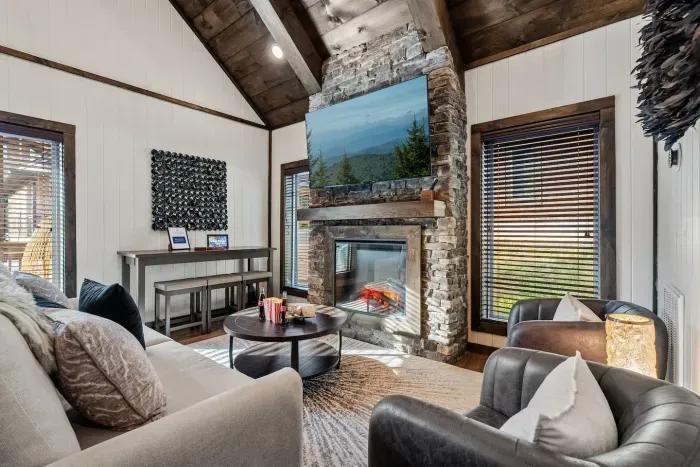 A cozy living room with a glowing electric fireplace, comfy seating for everyone, and the perfect setup for movie nights or quiet evenings in