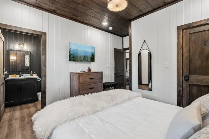 Bedroom two comes with a queen bed, ensuite full bathroom, and private access to the back porch