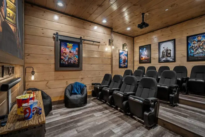 Our downstairs theater is designed for everyone — with 13 recliner-style seats plus 2 oversized beanbags up front, perfect for stretching out. Framed by classic movie posters like Toy Story.