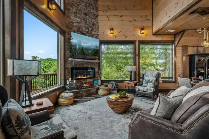 A stone fireplace anchors the cozy living room, creating the perfect spot to curl up with a book or unwind by the fire after a day in the mountains.
