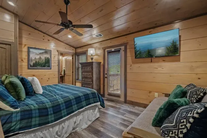 The fourth bedroom upstairs pairs classic green plaid bedding with a futon couch, giving guests both comfort and flexibility. Perfect for kids, teens, or anyone who loves a cozy cabin vibe.