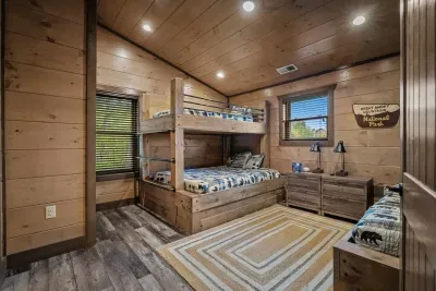 Styled in blue plaid with playful bear details, this bunk room is a true cabin favorite. Perfect for sleepovers, laughter, and late-night memories.