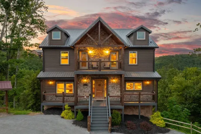 As the sun sets, the front of the cabin glows through its wide open windows, reflecting the cotton candy skies of the Smokies.