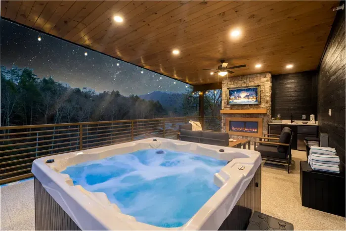 Rooftop outdoor living space with hot tub and fireplace