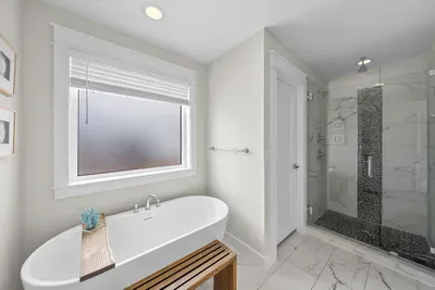 The primary bath earns its keep: a freestanding soaking tub, a dual-head walk-in shower with a rainfall head, and a dual-sink vanity. Take the long shower. Nobody's waiting.
