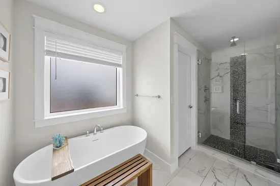 The primary bath earns its keep: a freestanding soaking tub, a dual-head walk-in shower with a rainfall head, and a dual-sink vanity. Take the long shower. Nobody's waiting.