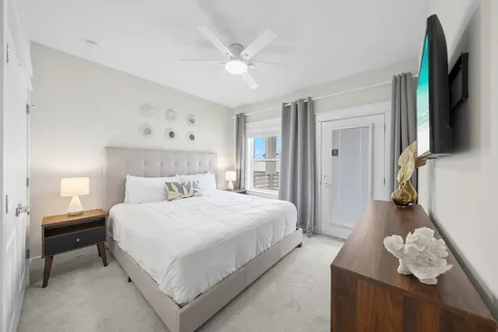 A king bedroom with its own smart TV and a door out to the shared balcony, so you can catch the morning air before the house wakes up.
