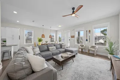 There's room for the whole group on the sectional, with a ceiling fan overhead and windows on three sides.