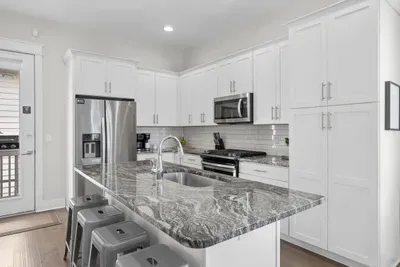 A genuinely well-stocked kitchen: gas range, stainless appliances, and a granite island with room to spread out. Whatever you cook for eight, the pans are already here.