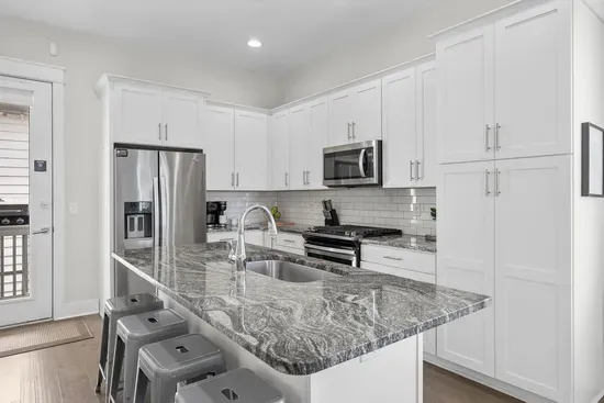 A genuinely well-stocked kitchen: gas range, stainless appliances, and a granite island with room to spread out. Whatever you cook for eight, the pans are already here.