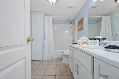 Main-level full bathroom with tub/shower, accessible from both the bedroom and main hallway.
