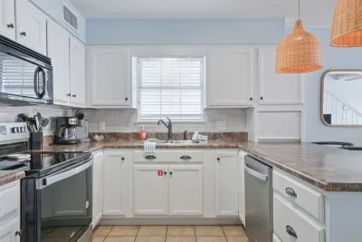 Bright, fully equipped kitchen with stainless steel appliances and ample counter space—perfect for preparing meals and gathering after a day at the beach.
