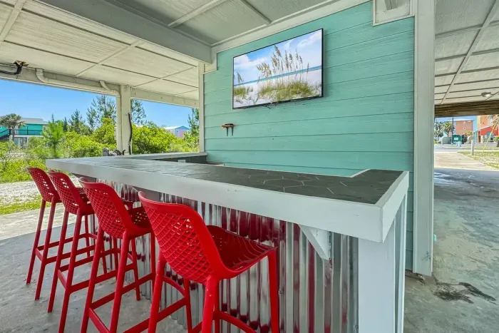 Kick back at your outdoor bar! Complete with bar stools, mounted smart Roku TV, and cool coastal vibes. 
*This is a duplex and the outdoor space is shared with guests in the unit next door