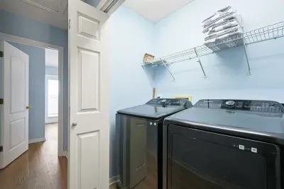 Convenient in-unit laundry closet with full-size washer and dryer, shelving for towels and supplies, and easy access from the main living level—perfect for longer stays or beach days.