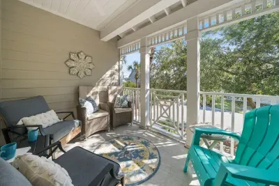 The covered patio off the living room is made for morning coffee and afternoon cocktails, with cushioned seating and a bright Adirondack chair looking out to the trees.