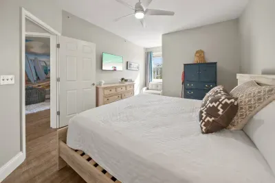 A wall-mounted TV, a dresser and a closet make this bedroom easy to unpack in and settle into after a day at the beach.