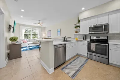 A bright kitchen open to the living area, with stainless appliances, white cabinets and plenty of counter space. Everything you need to cook for the whole group.