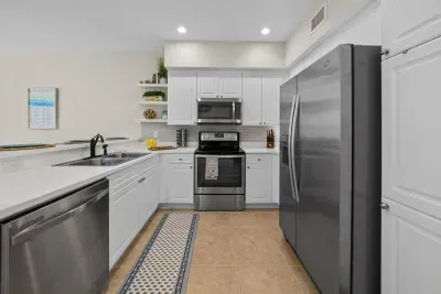Refrigerator, range, over-the-range microwave and dishwasher are all within reach, with a runner rug underfoot for long mornings at the stove.
