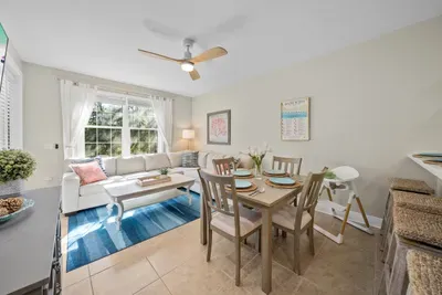 The dining table sits right in the living area, so dinner, cards and coffee all happen in the same sunny spot. A ceiling fan overhead keeps it comfortable.