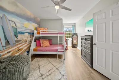 Another look at the kids' hangout: bunk beds, a dresser, a big floor pouf and space to spread out, with the arcade games waiting in the corner.
