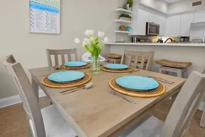 The dining table set for a family dinner, with room for the whole crew and a bright kitchen just steps away.