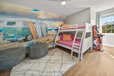 The bunk room is a full kids' hangout: a double on the bottom, a twin on top, a surf van mural and two arcade games, NBA Jam and Ms. Pac-Man/Galaga. Sleeps three, and the kids will want to move in.