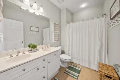 A shared bath with a double vanity and a tub and shower combo, built for busy mornings with a full house.