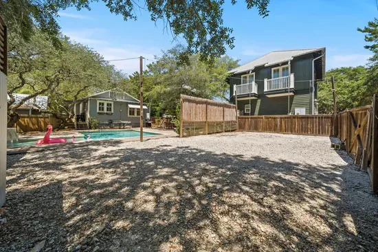 An additional parking pad at the back of the property offers extra space for vehicles and connects right to the pool area.