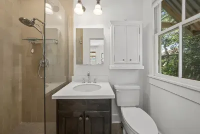 The guest bedroom's private ensuite keeps things simple with a clean vanity and a walk-in tile shower.
