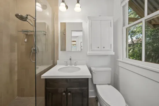 The guest bedroom's private ensuite keeps things simple with a clean vanity and a walk-in tile shower.