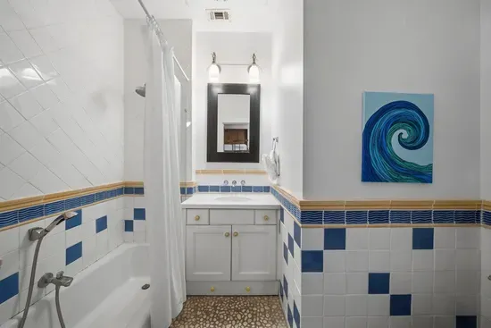 The bunk room's ensuite keeps the kids happy with a tub-and-shower combo and playful coastal touches.