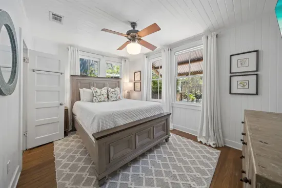A bright, restful guest bedroom with a queen bed and its own private ensuite, set just off the kitchen.