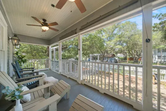 The screened porch is a breezy, bug-free spot to relax, with ceiling fans overhead and the backyard and pool just steps away.