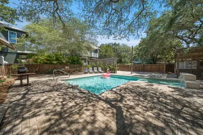A roomy paver patio wraps the pool with sun loungers and plenty of space to spread out between dips.