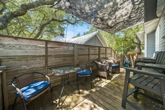 Just off the kitchen, a shaded back deck with ample seating is the perfect spot for morning coffee or an after-beach drink.