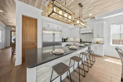 Four bar stools, a full stainless fridge, and everything you need for a week of cooking in — the kitchen works as hard as you want it to.