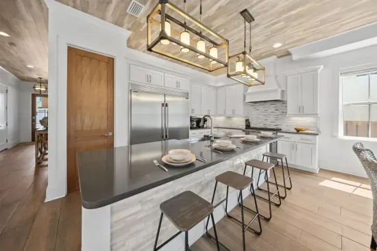 Four bar stools, a full stainless fridge, and everything you need for a week of cooking in — the kitchen works as hard as you want it to.