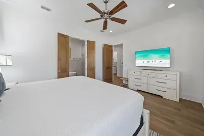 A self-contained retreat on the ground floor — king bed, smart TV, en-suite bath with soaking tub and walk-in shower, and a large walk-in closet.
