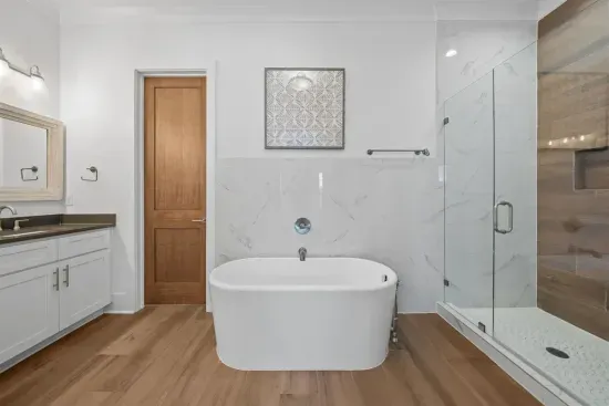 Soak in the freestanding tub after a long beach day or rinse off in the walk-in tile shower — the en-suite bath makes the ground-floor suite feel like a spa.