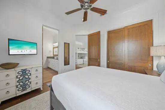 A queen bedroom with its own TV, closet, and direct bath access — plus a second door to the bunk loft for easy flow between rooms.