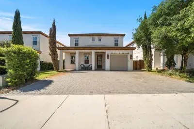 A striking 2-story home with a wide paver driveway, covered front porch, and room for 3+ vehicles — curb appeal that lives up to what's inside.