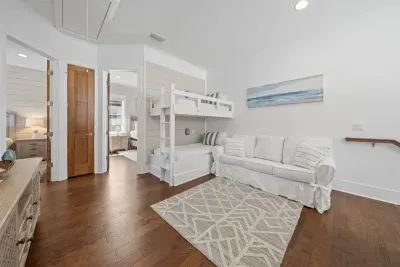 The bunk loft sits at the center of the 2nd floor — twin bunks, a sofa, and open doors to both queen bedrooms make it a natural hub for the family.