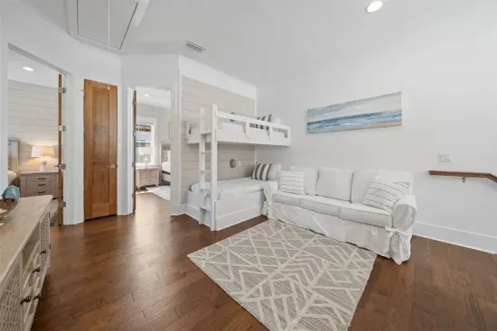 The bunk loft sits at the center of the 2nd floor — twin bunks, a sofa, and open doors to both queen bedrooms make it a natural hub for the family.