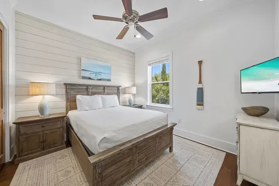Coastal details done right — shiplap wall, driftwood bed frame, and soft lighting make this bedroom feel like a boutique hotel.